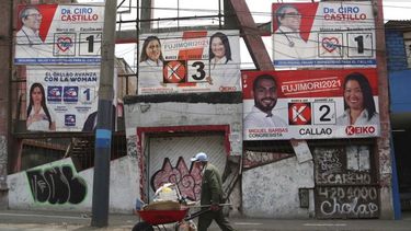 Un hombre empuja una carretilla frente a un muro adornado con propaganda electoral en el barrio de Ventanilla en las afueras de Lima, Perú, el miércoles 10 de marzo de 2021. Un mes antes de las elecciones presidenciales de Perú, los peruanos deben elegir entre 19 candidatos. &nbsp;