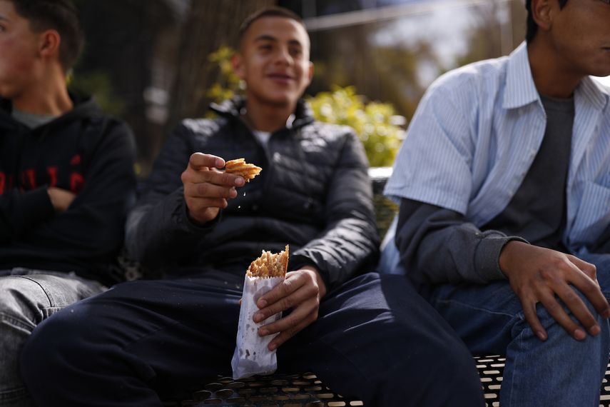 Un hombre come churros de una delgada bolsa de papel comprados de un vendedor ambulante que llevaba su mercanc&iacute;a en una canasta en Ciudad de M&eacute;xico el martes 31 de diciembre de 2019.&nbsp;