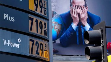 Precios de la gasolina en California. Detrás una valla publicitaria.