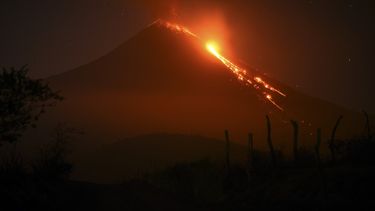 El volcán Pacaya entra en erupción visto desde la aldea Rodeo en el municipio de San Vicente Pacaya, a unos 50 km al sur de la ciudad de Guatemala, el 5 de marzo de 2021. Rodeo y Patrocinio son las aldeas más afectadas por las cenizas arrojadas por el volcán Pacaya, cuyas calles atestiguan la furia de las erupciones y los fuertes retumbos que se escuchan a kilómetros de distancia