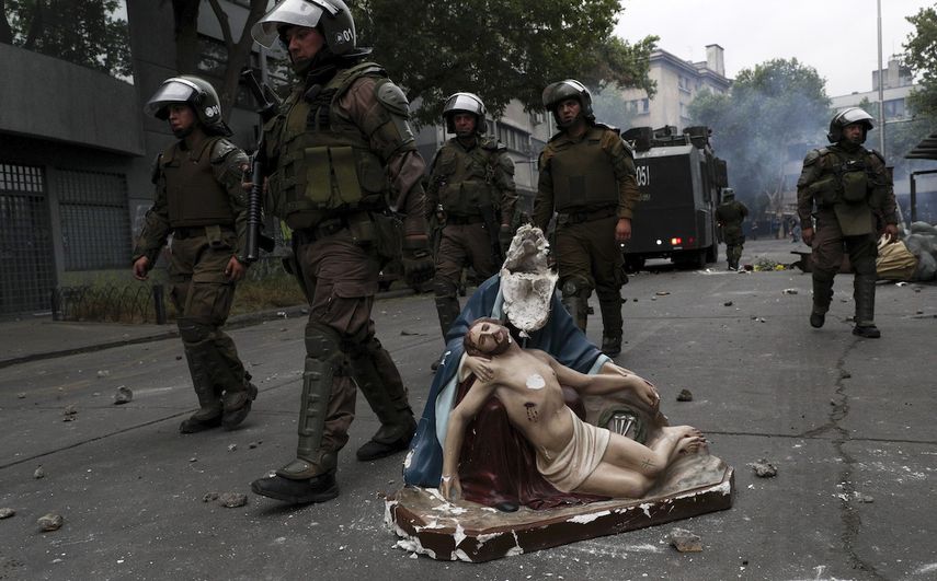La polic&iacute;a avanza hacia manifestantes contra el gobierno junto a una estatua religiosa que fue removida de una iglesia y da&ntilde;ada en Santiago de Chile el viernes 8 de noviembre de 2019.&nbsp;