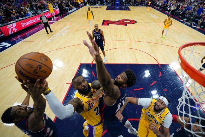 LeBron James, centro, de los Lakers de Los Ángeles, se alza para intentar un tiro entre DeAnthony Melton, izquierda, y Joel Embiid, de los 76ers de Filadelfia, durante la segunda mitad del juego de baloncesto de la NBA, el lunes 27 de noviembre de 2023, en Filadelfia.&nbsp;