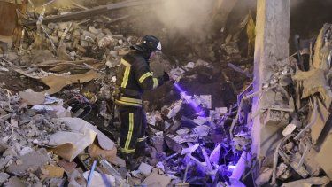 Un trabajador de emergencias de Donetsk busca en el lugar donde un centro comercial quedó destruido por lo que autoridades rusas en Donetsk describieron como un ataque de fuerzas ucranianas, en la zona controlada por Rusia de la región de Donetsk, este de Ucrania, el lunes 16 de enero de 2023.&nbsp; 