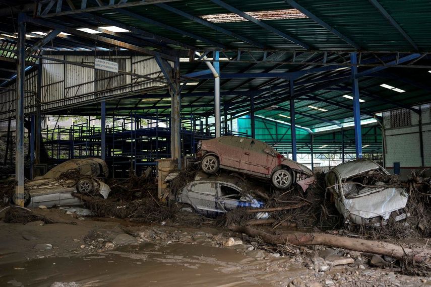 Varios automóviles yacen apilados en un taller luego de que intensas lluvias provocaron inundaciones repentinas y el desbordamiento del río Las Tejerías, el domingo 9 de octubre de 2022, en Las Tejerías, Venezuela.