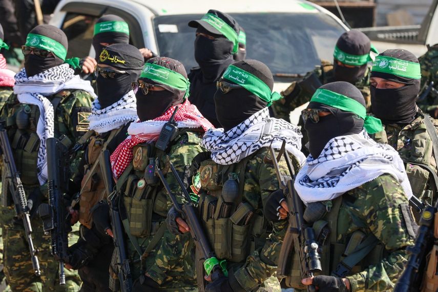 Combatientes de Hamás aseguran un área en una plaza antes de liberar a cuatro rehenes israelíes a un equipo de la Cruz Roja en la ciudad de Gaza el 25 de enero de 2025.