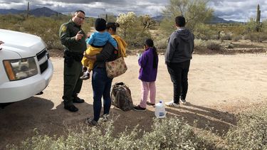 Registro del portavoz de la Patrulla Fronteriza, Daniel Hernández (i), al hablar con una inmigrante hondureña, tras entregarse junto a sus tres hijos de 2, 9 y 14 años, en la frontera de Arizona con México.