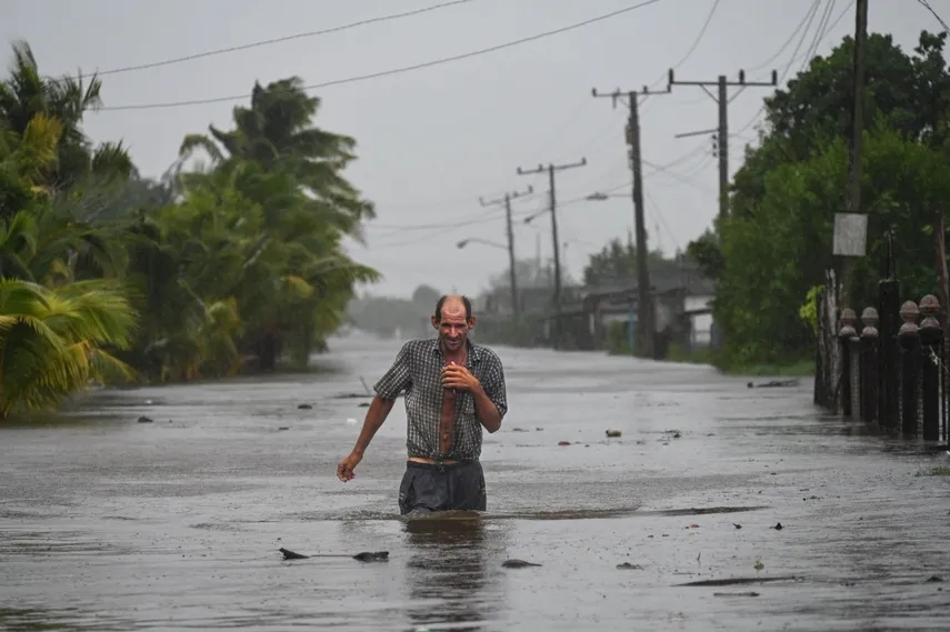 Residentes de la ciudad costera de Guanimar en la provincia de Artemisa, al suroeste de La Habana, caminan por una calle inundada tras el paso del huracán Helene el 25 de septiembre de 2024. La tormenta tropical Helene se convirtió en huracán a media mañana en el Golfo de México.