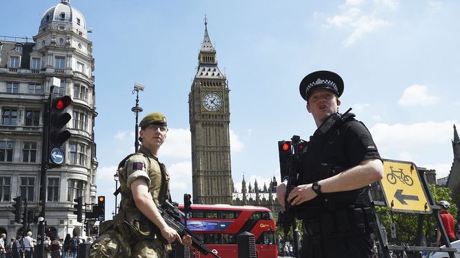 Un soldado y un policía británico vigilan cerca del Parlamento en Londres días después del atentado perpetrado en Manchester.