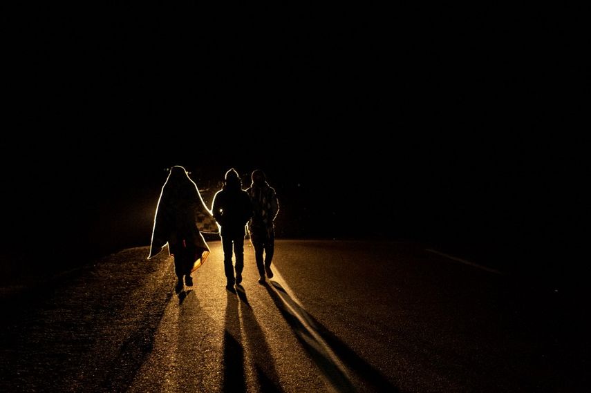 El migrante venezolano Rubi Alexander G. (L) y amigos caminan bajo temperaturas frías de noche por la carretera que une Colchane con Iquique, luego de cruzar desde Bolivia, en Huara, Chile, el 17 de febrero de 2021. Cruzando las tierras altas de la frontera entre Bolivia y Chile a pie es la parte más difícil del viaje que atraviesan los migrantes venezolanos en su camino hacia Iquique o Santiago.