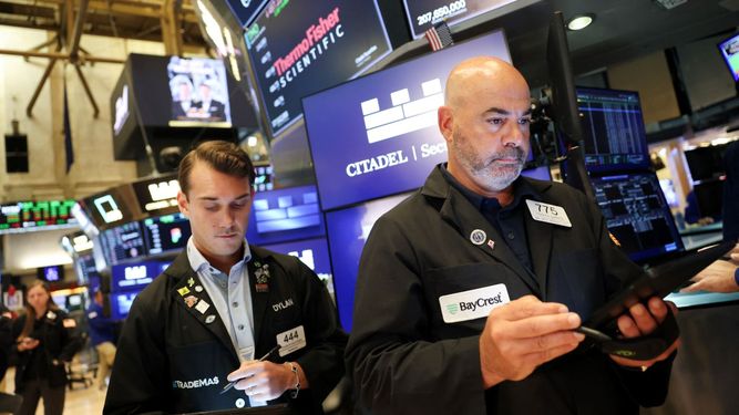 Agentes de Wall Street trabajan en el piso de remate.