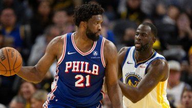 El pívot de los 76ers de Filadelfia Joel Embiid observa antes de pasar el balón mientras lo defiende el alero de los Warriors de Golden State Draymond Green en el encuentro del martes 30 de enero del 2024.&nbsp;