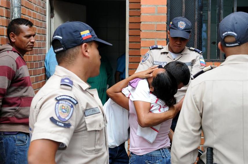 Familiares de una víctima de intoxicación masiva lloran en las afueras de la cárcel de Uribana, en Barquisimeto, estado de Lara (Venezuela). (EFE)