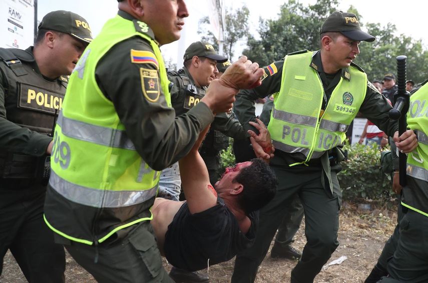 Miembros de la Policía de Colombia trasladan a un joven herido en los enfrentamientos con la PNB y los grupos paramilitares que actúan con la autorización del régimen.&nbsp;