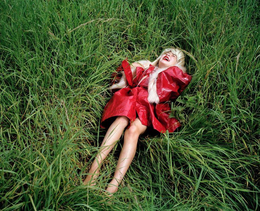 La fotógrafa Lúa Ribeira expone su nueva muestra en San Sebastián. Fotografía Tumbada con abrigo rojo de Lúa Ribeira.