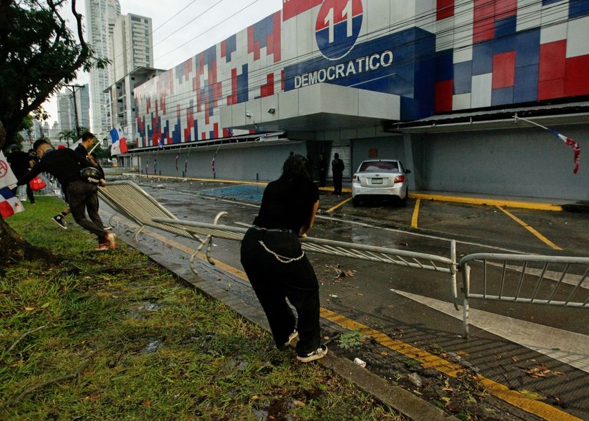 Los manifestantes derriban una barrera en la sede del Partido Revolucionario Democrático (PRD) durante una protesta contra el alto costo de los alimentos y la gasolina en la Ciudad de Panamá, el 20 de julio de 2022