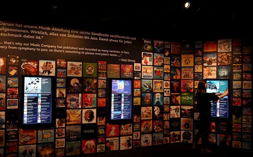 Una mujer toma una foto de exhibiciones en el espectáculo Disney 100 - The Exhibition en el pequeño salón olímpico en Munich, en el sur de Alemania, el 17 de abril de 2023.