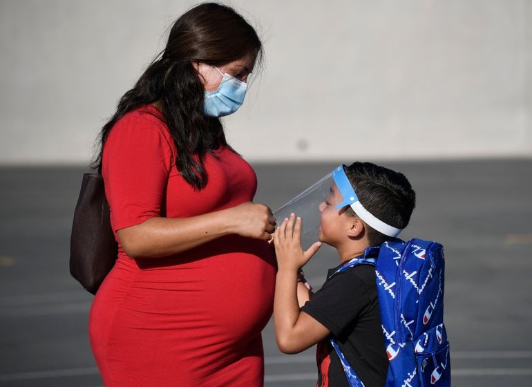 En esta imagen de archivo, tomada el 21 de julio de 2021, una madre ajusta la máscara de protección facial de su hijo en su primer día de clase en la escuela primaria Enrique S. Camarena, en Chula Vista, California, donde se exigirá vacuna contra COVID-19 a los escolares