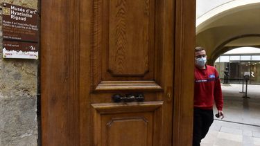 Un empleado cierra la puerta principal del museo Hyacinthe-Rigaud en Perpignan, en el sur de Francia, el 15 de febrero de 2021, después de que el tribunal administrativo de Montpellier descartara la decisión del ayuntamiento de Perpiñán de reabrir museos.&nbsp; 