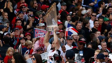 El jugador de los Medias Rojas de Boston, Shane Victorino, centro, levanta el trofeo de campeones de la Serie Mundial en el desfile en Boston. (AP Photo/Michael Dwyer)