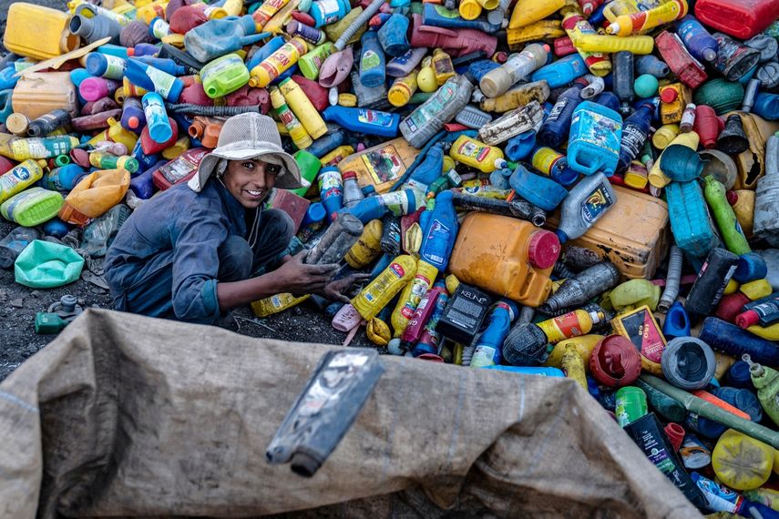 Un joven trabajador afgano clasifica latas de plástico reciclables en un depósito de reciclaje en las afueras de Kabul el 5 de agosto de 2025.