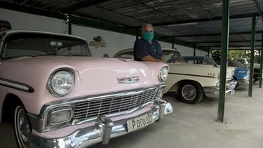 Un hombre posa&nbsp;junto a varios autos antiguos&nbsp;de los usados para transportar turistas por La Habana, Cuba, en tiempos en los que los negocios privados de la isla sufren los efectos económicos negativos que acompañan a la pandemia de COVID-19.