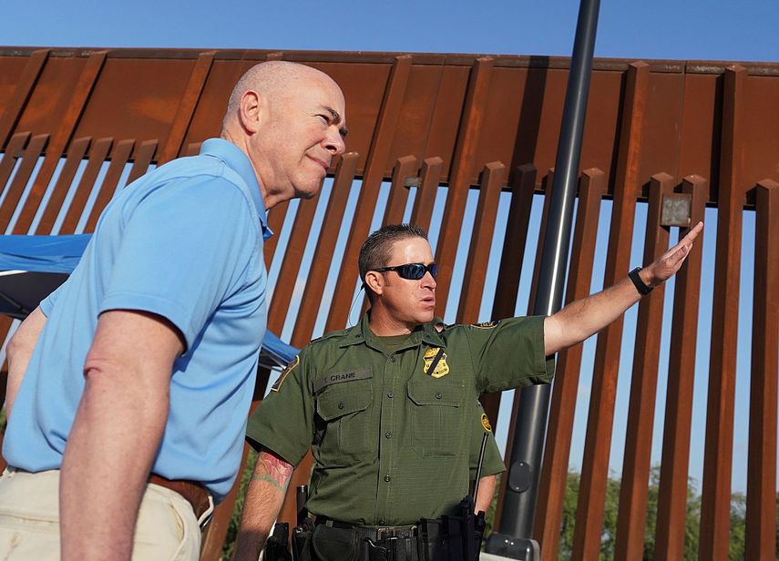 El secretario de Seguridad Nacional, Alejandro Mayorkas, escucha a Anthony Crane, agente de la Patrulla Fronteriza, durante un recorrido de un tramo del muro fronterizo, el martes 17 de mayo de 2022, en Hidalgo, Texas.&nbsp;