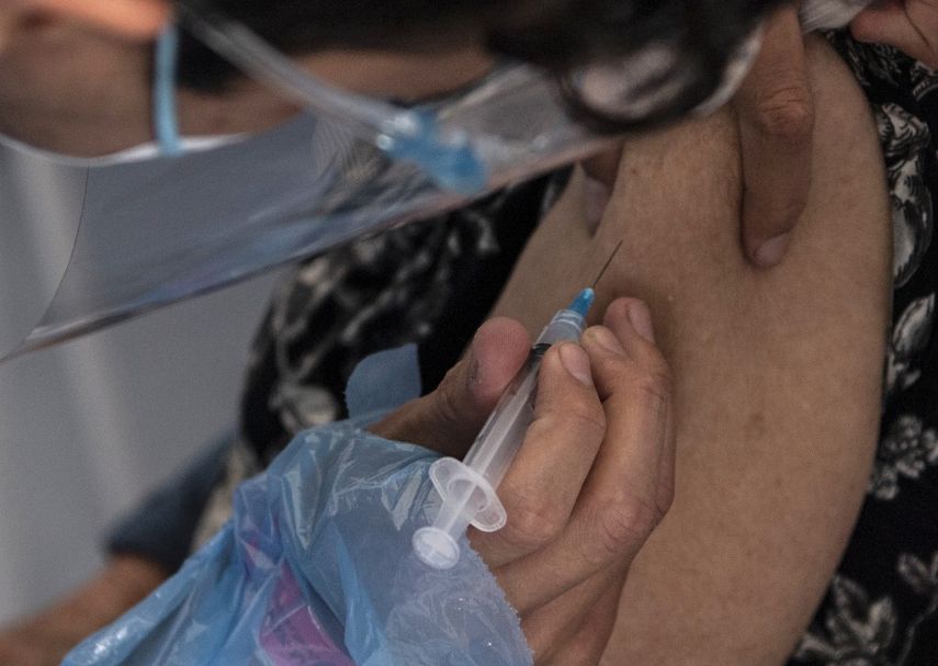 Un trabajador de la salud administra una dosis de la vacuna Sinovac CoronaVac de China a una persona en un centro de vacunación montado en el Estadio Bicentenario en Santiago, mientras comienza una campaña masiva de vacunación contra el nuevo coronavirus, COVID-19, en Chile, el 3 de febrero de 2021.