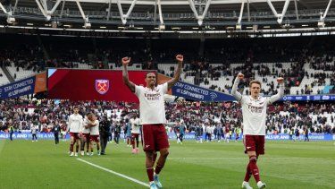 El defensa brasileño del Arsenal, Gabriel Magalhaes (número 06), y el centrocampista noruego del Arsenal, Martin Odegaard (número 08), celebran con los aficionados después de que el Arsenal ganara el partido de la Premier League inglesa entre el West Ham United y el Arsenal en el London Stadium.