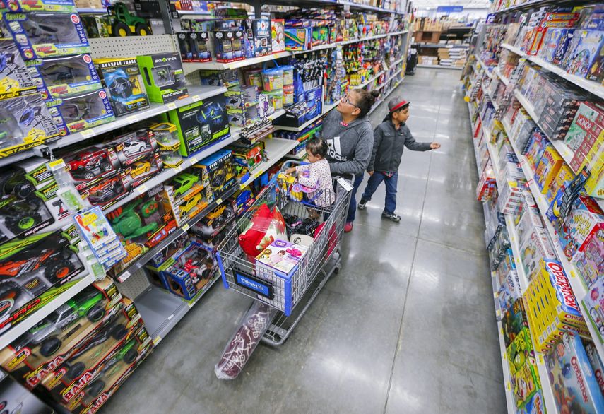 Una madre mira con atención las ofertas en una tienda.