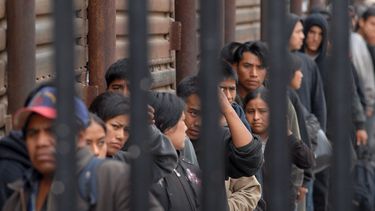 Indocumentados forman una fila mientras esperan ser deportados en San Diego, California (EEUU), en el cruce peatonal fronterizo que conduce a Tijuana, México.