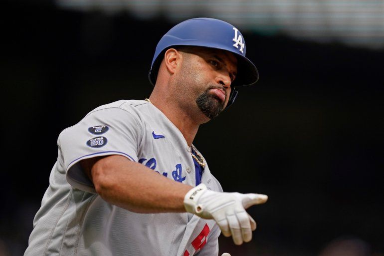 Albert Pujols, de los Dodgers, apunta mientras recorre las bases luego de conectar un jonrón solitario 