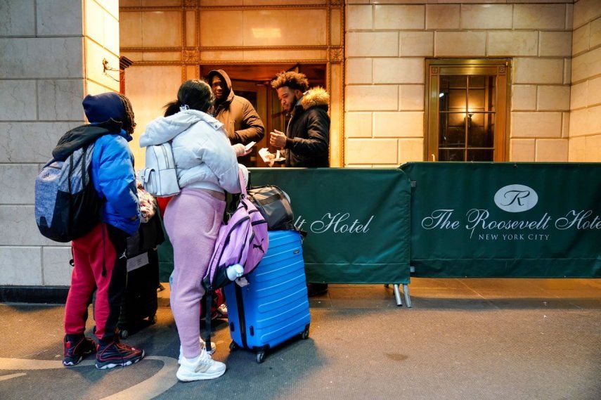 Una familia de migrantes muestra su documentación a los guardias de seguridad en el Hotel Roosevelt, el martes 9 de enero de 2024, en la ciudad de Nueva York.&nbsp;