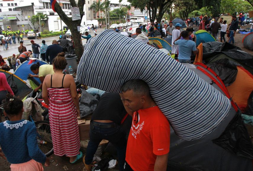 Unos 400 ciudadanos venezolanos se encuentran en un lote aledaño a la terminal de transportes de Cali, Colombia, donde pernoctan en carpas desde hace varias semanas.