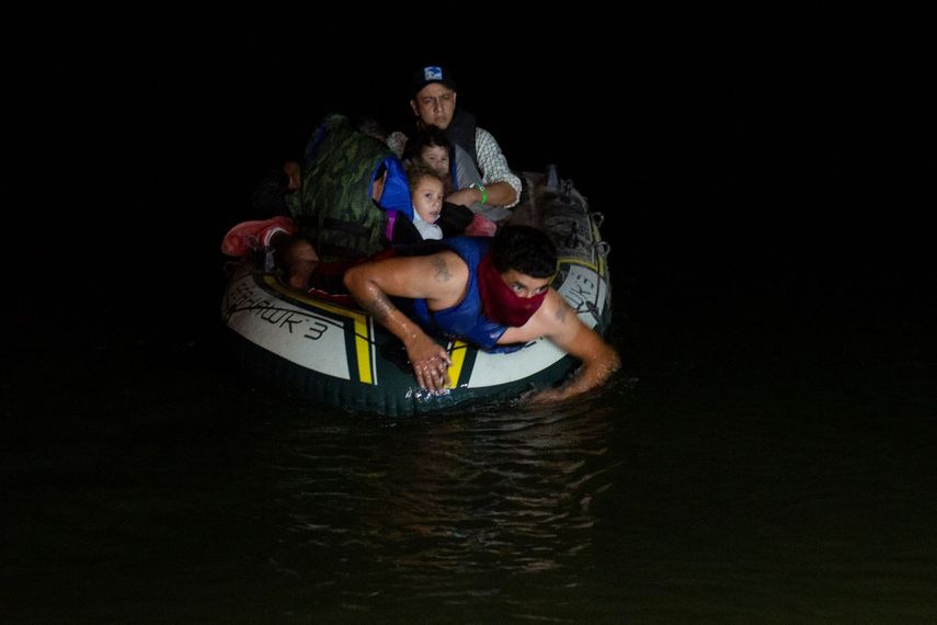 En esta foto del 30 de marzo del 2021, un contrabandista lleva a migrantes, mayormente centroamericanos, en una balsa inflable hacia Estados Unidos