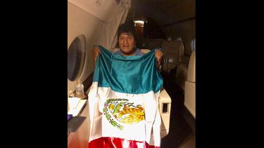 En esta imagen publicada por el ministro mexicano de Exteriores, Marcelo Ebrard, se ve al expresidente de Bolivia Evo Morales sosteniendo una bandera mexicana a bordo de un avi&oacute;n de la Fuerza A&eacute;rea mexicana, el lunes 11 de noviembre de 2019.&nbsp;