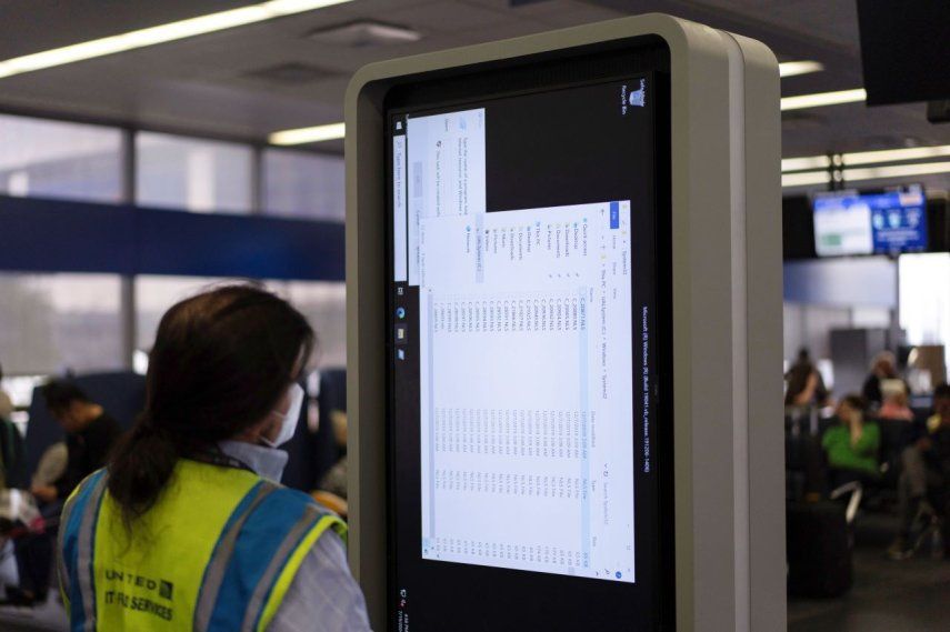 Una técnico trabaja en un monitor de información cerca de la zona de embarque de United Airlines en el aeropuerto internacional OHare en Chicago, el 19 de julio de 2024.