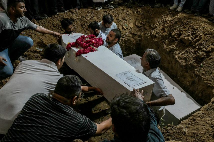 La gente baja el ataúd de una víctima, que murió en el accidente aéreo de Air India, durante una ceremonia de entierro en Ahmedabad el 15 de junio de 2025. Las familias afligidas celebraron funerales en la India el 15 de junio para sus familiares que se encontraban entre las al menos 279 personas que murieron en uno de los peores accidentes aéreos del mundo en décadas.