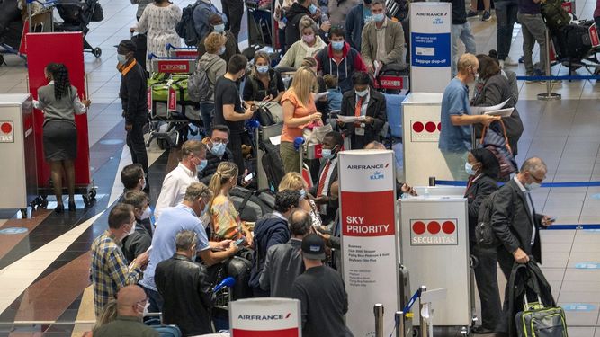 Decenas de personas hacen fila para tomar un vuelo de Air France a París en el aeropuerto internacional Tambo en Johannesburgo, Sudáfrica, el viernes 26 de noviembre de 2021.