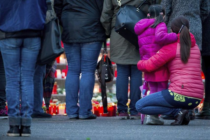 Varias personas depositan flores y velas en memoria de los pasajeros en el avión siniestrado en los Alpes franceses, frente al instituto Joseph König, en la localidad de Haltern am See, Alemania. (EFE)