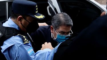 Policías escoltan al expresidente Juan Orlando Hernández a su llegada al Palacio de Justicia para asistir a su primera audiencia de extradición en Tegucigalpa, el 16 de febrero de 2022.