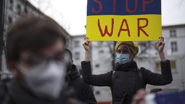 Una mujer con un cartel con los colores de la bandera ucraniana que dice Alto a la guerra asiste a una manifestación contra las tensiones entre Rusia y Ucrania, cerca de la embajada rusa en Berlín, Alemania, el martes 22 de febrero de 2022.&nbsp;