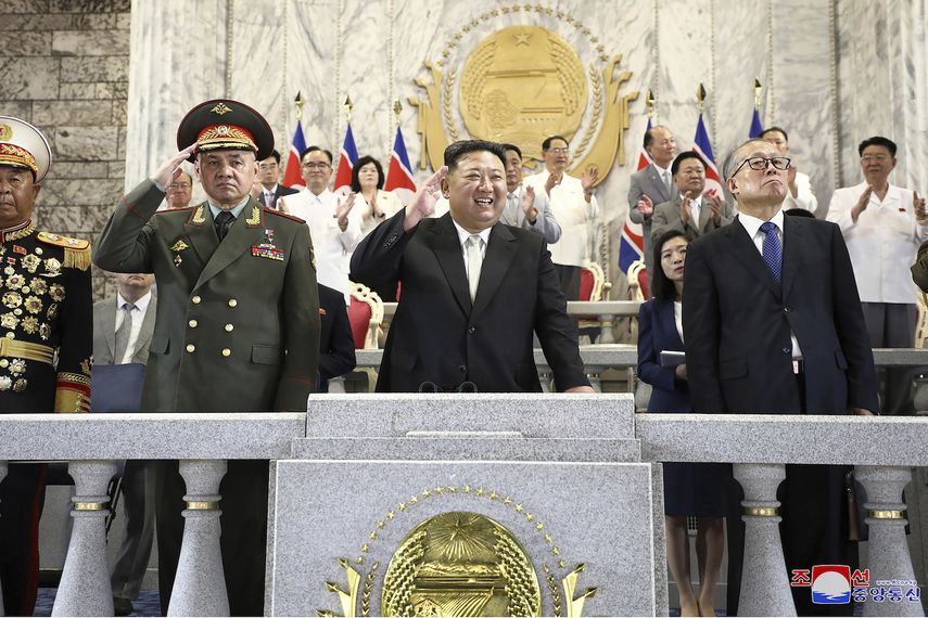 En esta imagen, distribuida por el régimen de Corea del Norte, el líder del país, Kim Jong Un (centro); el ministro de Defensa de Rusia, Sergei Shoigu (izquierda), y el vicepresidente del Comité Permanente de la Asamblea Popular Nacional de China, Li Hongzhong (derecha), asisten a un desfile militar para conmemorar el 70 aniversario del armisticio que suspendió los combates de la Guerra de Corea (1950-1953) en la Plaza Kim Il Sung, en Pyongyang, Corea del Norte, el 27 de julio de 2023. 
