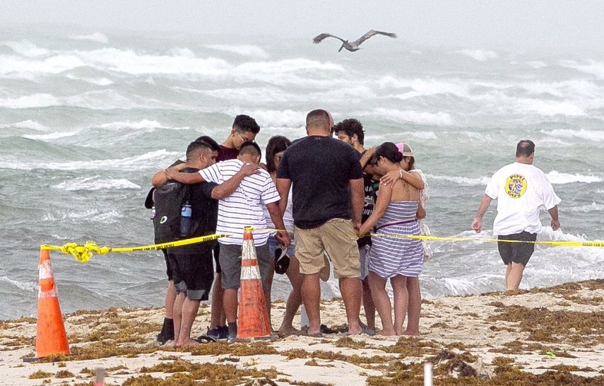 Varias personas se unen para orar el viernes 25 de junio de 2021 en la playa frente al sitio donde se colapsó el edificio Champlain Towers South Condo, en Surfside, Florida.&nbsp;