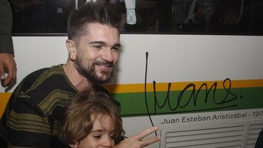 El colombiano Juanes y su pequeño hijo posan junto a la firma del cantautor. 