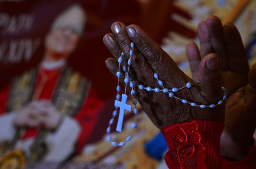 Una mujer reza junto a la imagen de Robert Francis Prevost, quien se convirtió en el Papa León XIV el 8 de mayo de 2025, frente a la catedral de Chiclayo, en el norte de Perú, el día de su elección como el 267º pontífice de la Iglesia católica.