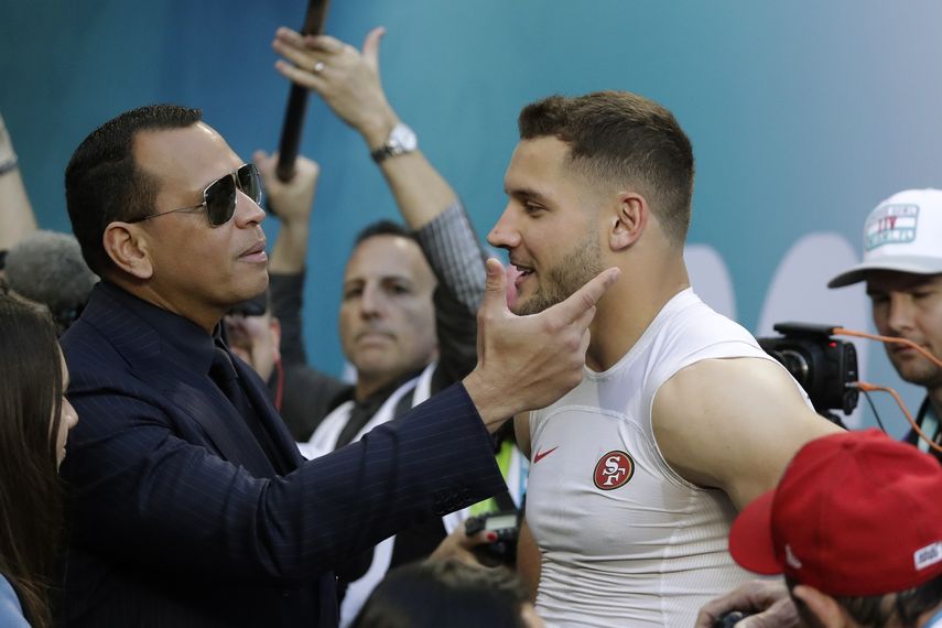 El ex astro de la MLB Alex Rodriguez, izquierda, saluda al ala defensiva Nick Bosa de los 49ers de San Francisco antes del Super Bowl 54 de la NFL entre los 49ers y los Chiefs de Kansas City el 2 de febrero de 2020 en Miami Gardens, Florida.