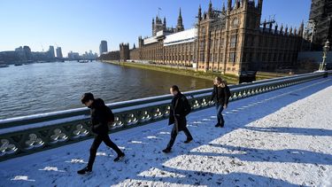 Varios viandantes caminan por la nieve sobre el Puente de Westminster, en Londres.