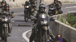 Un efectivo de la Guardia Nacional Bolivariana reprime a una estudiante durante una de las protestas opositoras en Caracas.