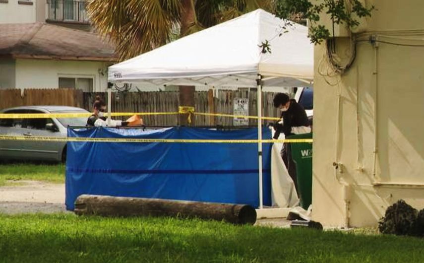 Policía científica de Broward examina los restos de una de las personas asesinadas, que fueron encontrados en un contenedor de basura, en Fort Lauderdale.