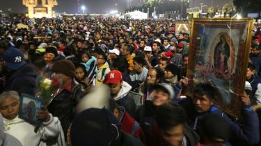 Gente pasa frente a un campamento de carpas camino de la Bas&iacute;lica de la Virgen de Guadalupe en Ciudad de M&eacute;xico en la peregrinaci&oacute;n anual, jueves 12 de diciembre de 2019.